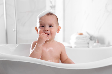 Photo of Cute little baby in bathtub at home