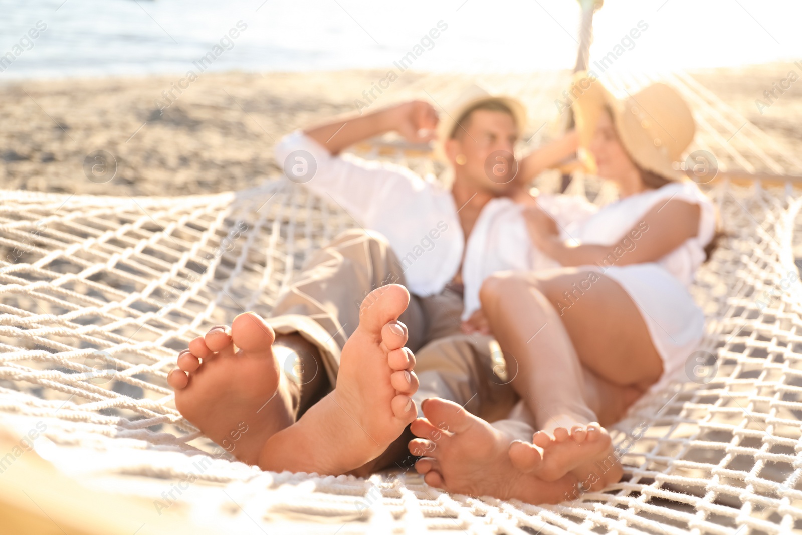 Photo of Couple relaxing in hammock outdoors, focus on legs