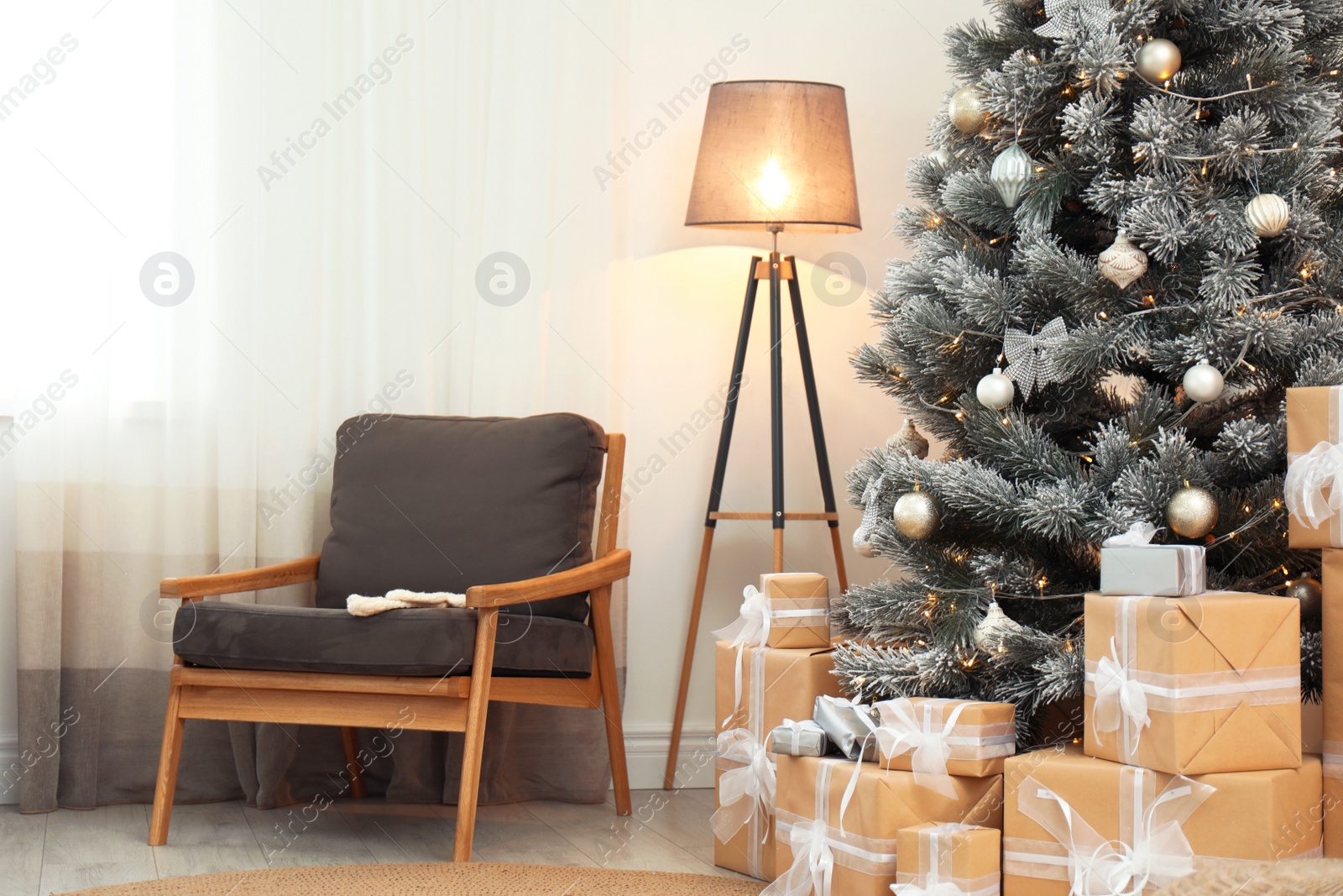 Photo of Stylish room interior with beautiful Christmas tree and gift boxes