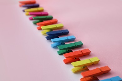 Photo of Many different colorful clothespins on pink background. Diversity concept