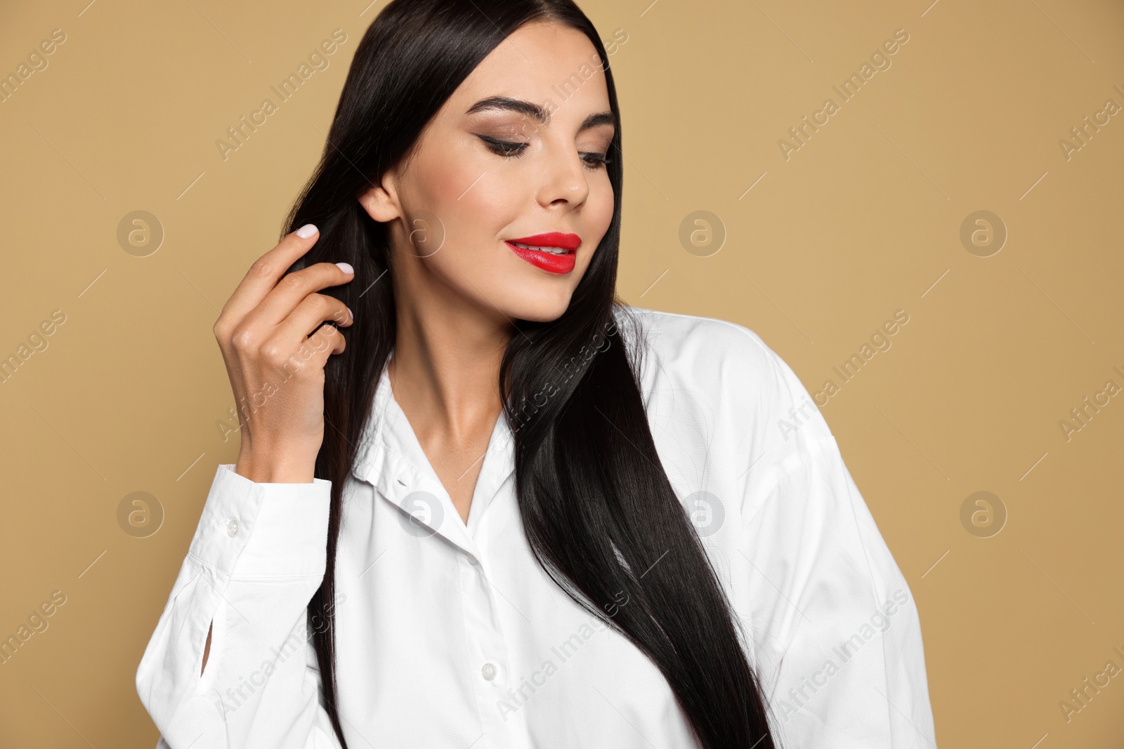 Photo of Portrait of young woman wearing beautiful red lipstick on beige background