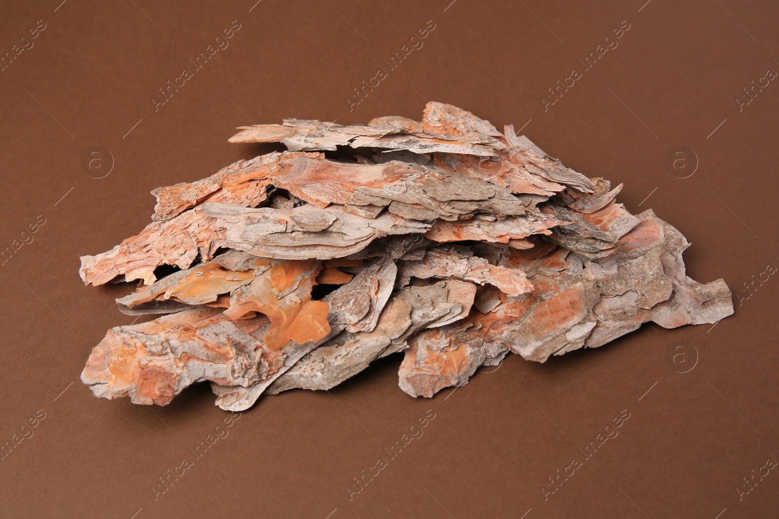 Photo of Pieces of tree bark on brown background