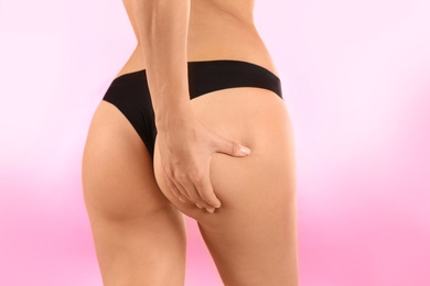 Photo of Closeup view of slim woman in underwear on color background. Cellulite problem concept