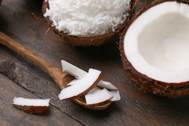 Photo of Coconut flakes, spoon and nut on wooden table