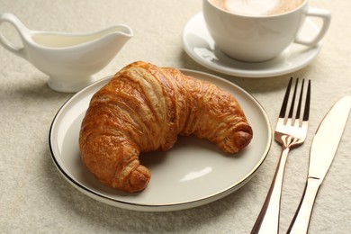 Delicious fresh croissant served on beige table