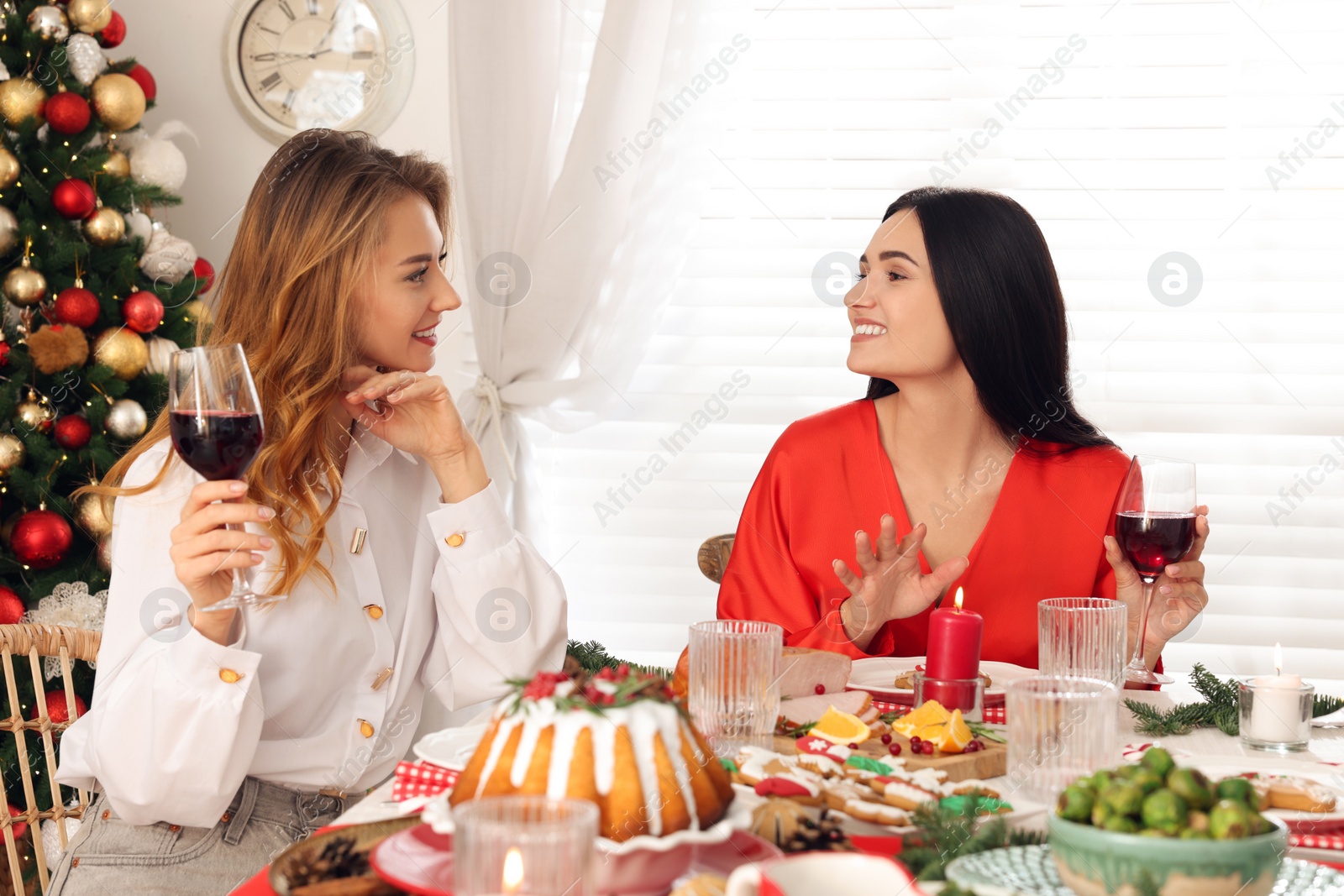 Photo of Happy family with their friends enjoying festive dinner at home. Christmas Eve celebration