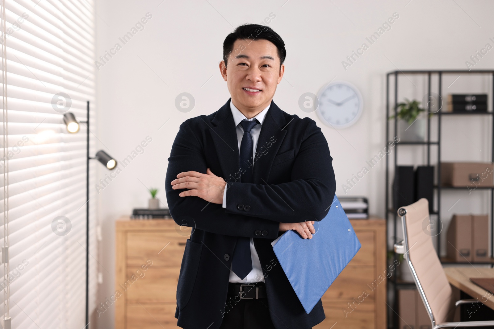 Photo of Portrait of happy notary with clipboard in office