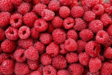 Photo of Heap of tasty ripe raspberries as background, top view