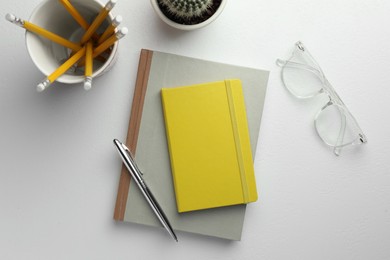 Photo of Flat lay composition with notebooks and pen on white table