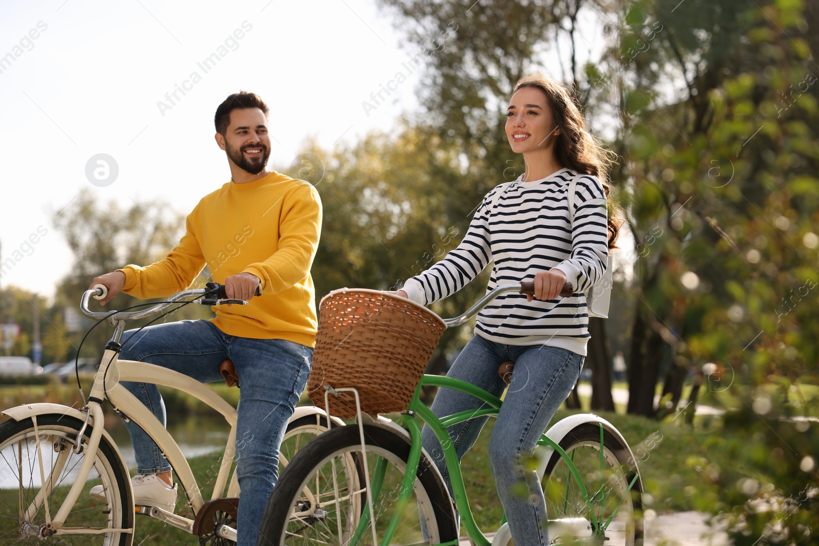 Photo of Beautiful young couple riding bicycles in park