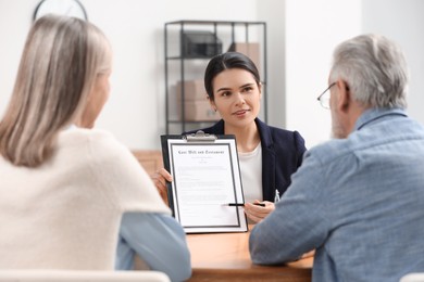 Notary showing senior man where to sign Last Will and Testament in office