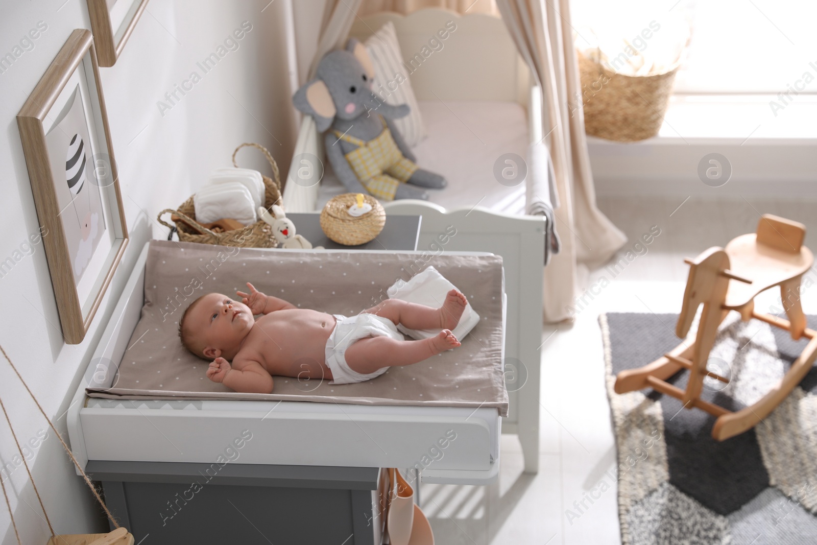 Photo of Cute little baby on changing table in room