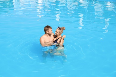 Happy young couple in swimming pool at resort