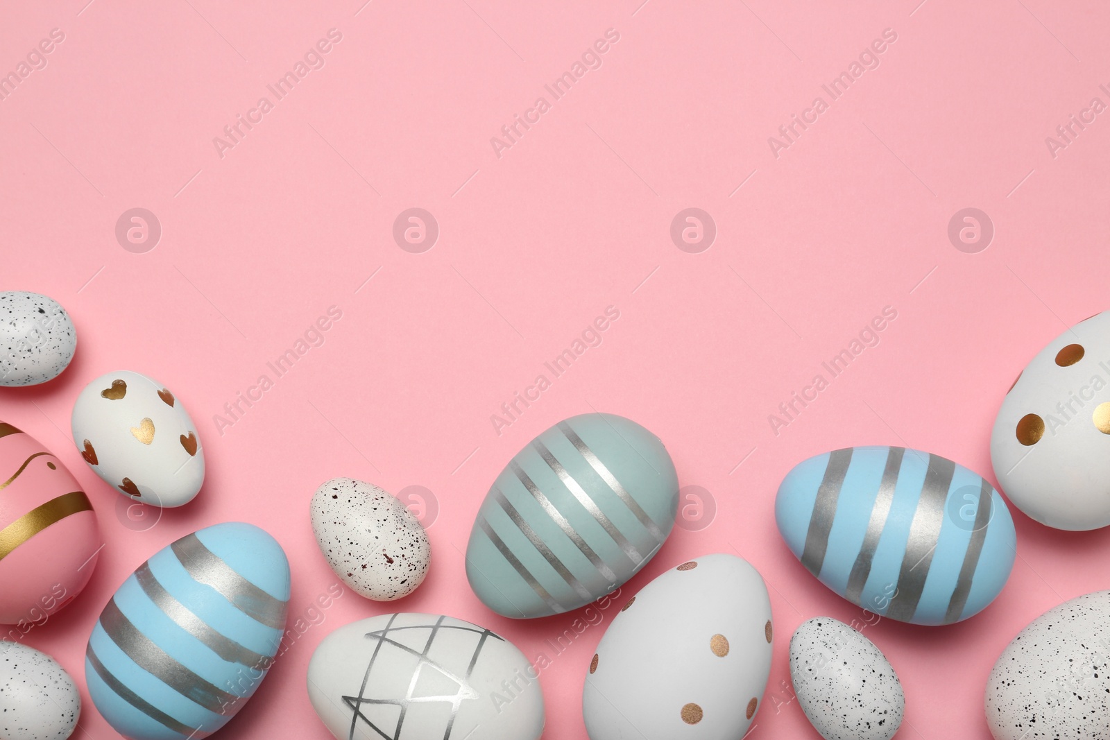 Photo of Many painted eggs on pink background, flat lay. Space for text