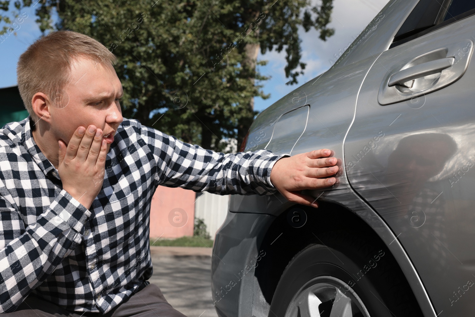 Photo of Stressed man near car with scratch outdoors