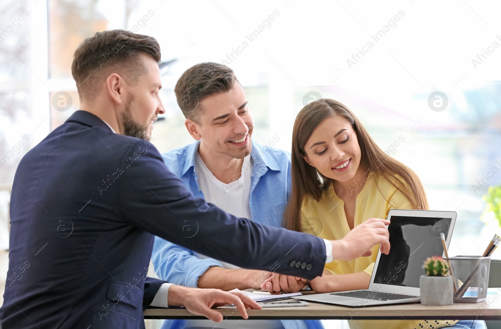 Photo of Young couple meeting with consultant in office