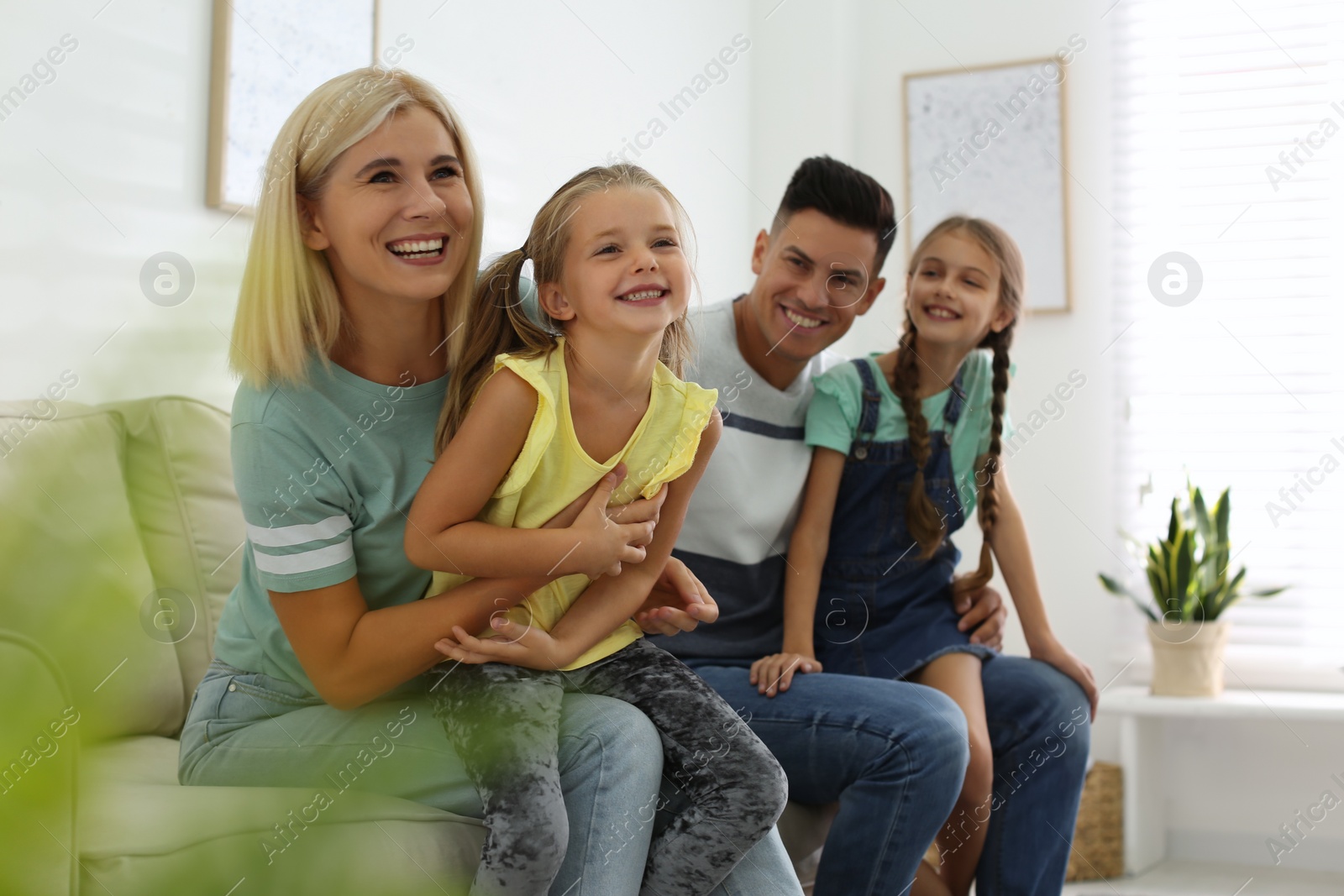 Photo of Happy family with children on sofa indoors