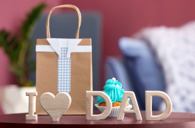 Phrase "I love dad" and gift bag on table. Father's day celebration