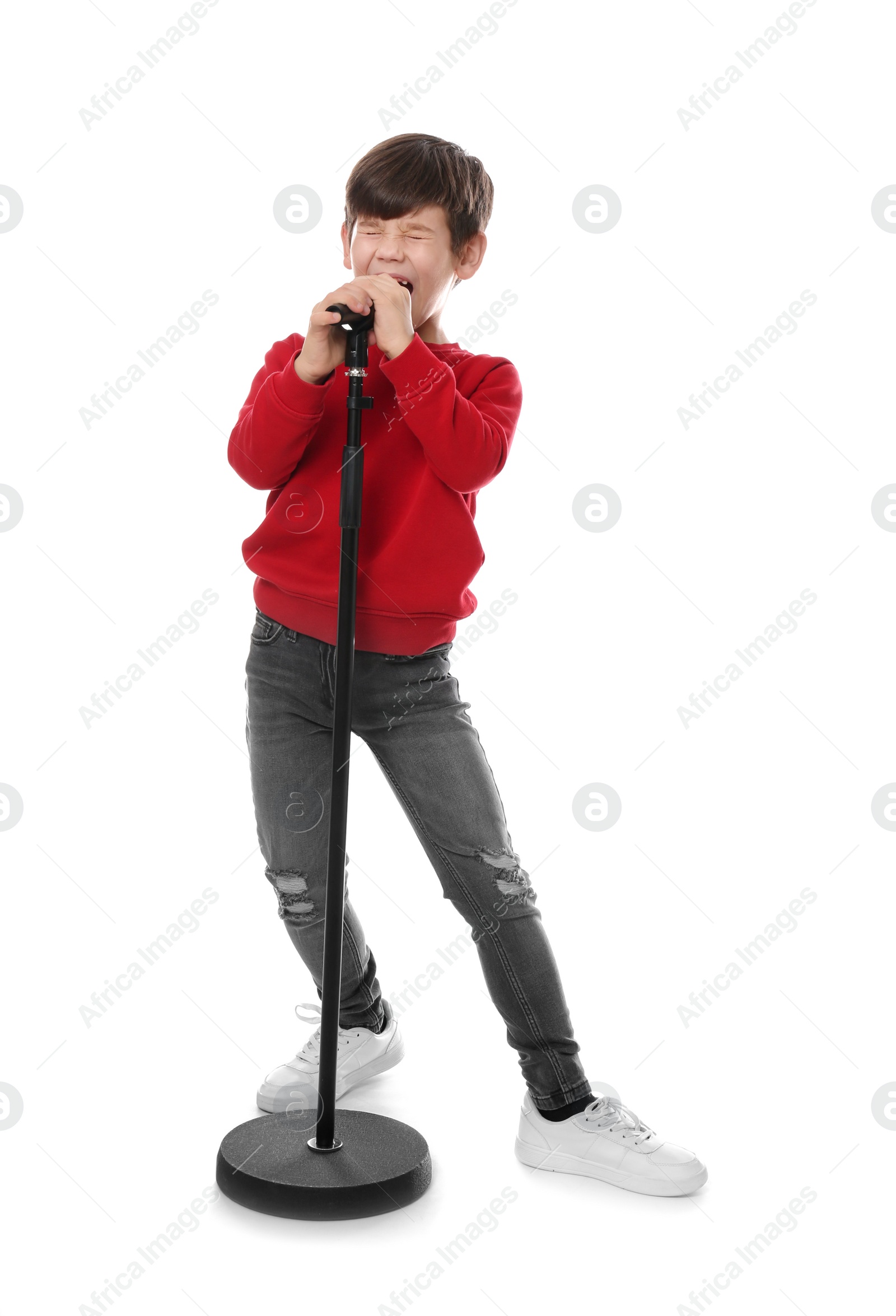 Photo of Cute little boy singing into microphone on white background