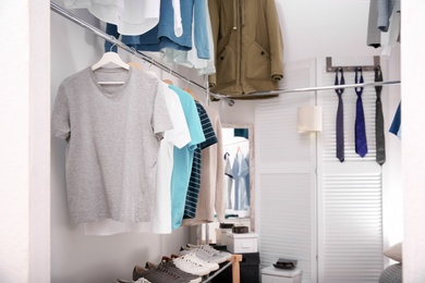 Modern dressing room with different stylish clothes and accessories