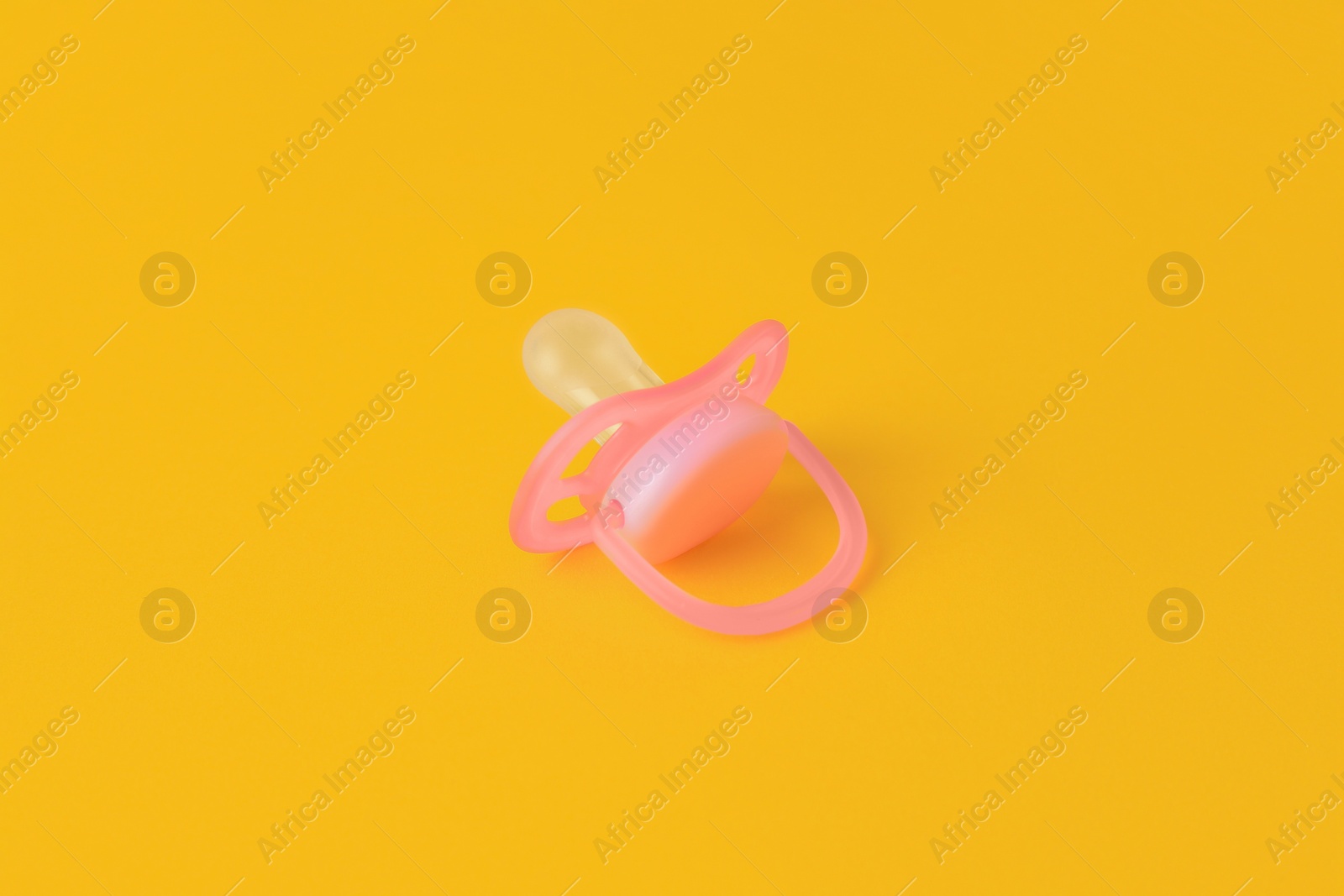 Photo of One new baby pacifier on orange background