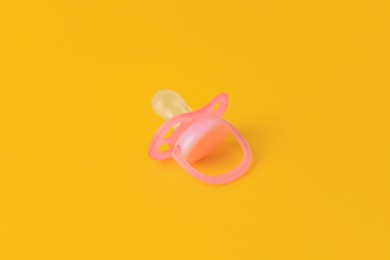 Photo of One new baby pacifier on orange background