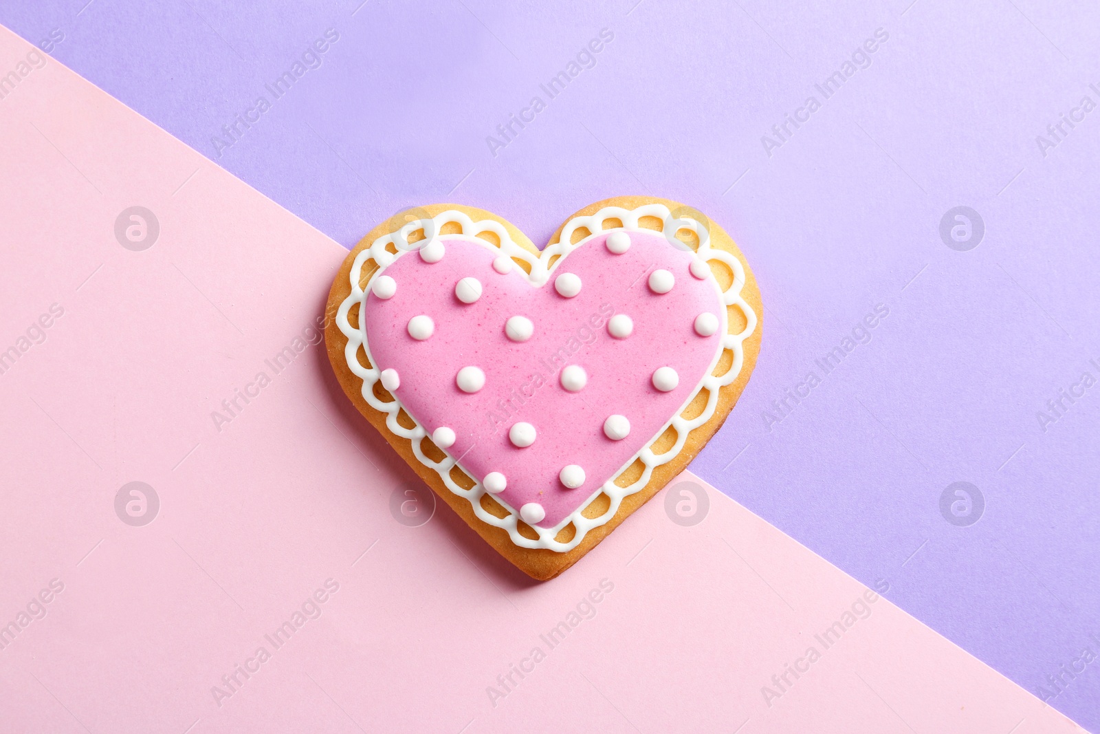 Photo of Decorated heart shaped cookie on color background, top view