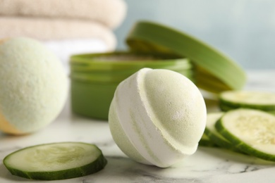 Photo of Bath bomb and cucumber slices on marble table