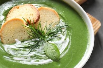 Photo of Fresh vegetable detox soup made of spinach with croutons in dish, closeup