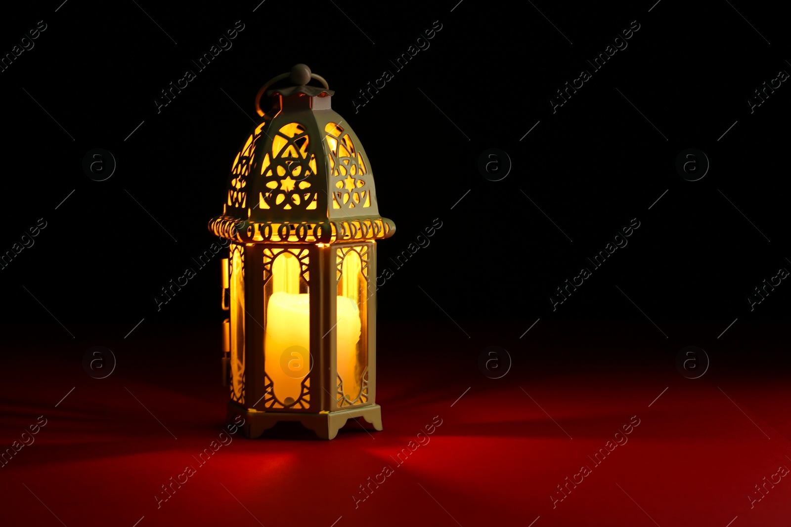 Photo of Decorative Arabic lantern on table against dark background. Space for text