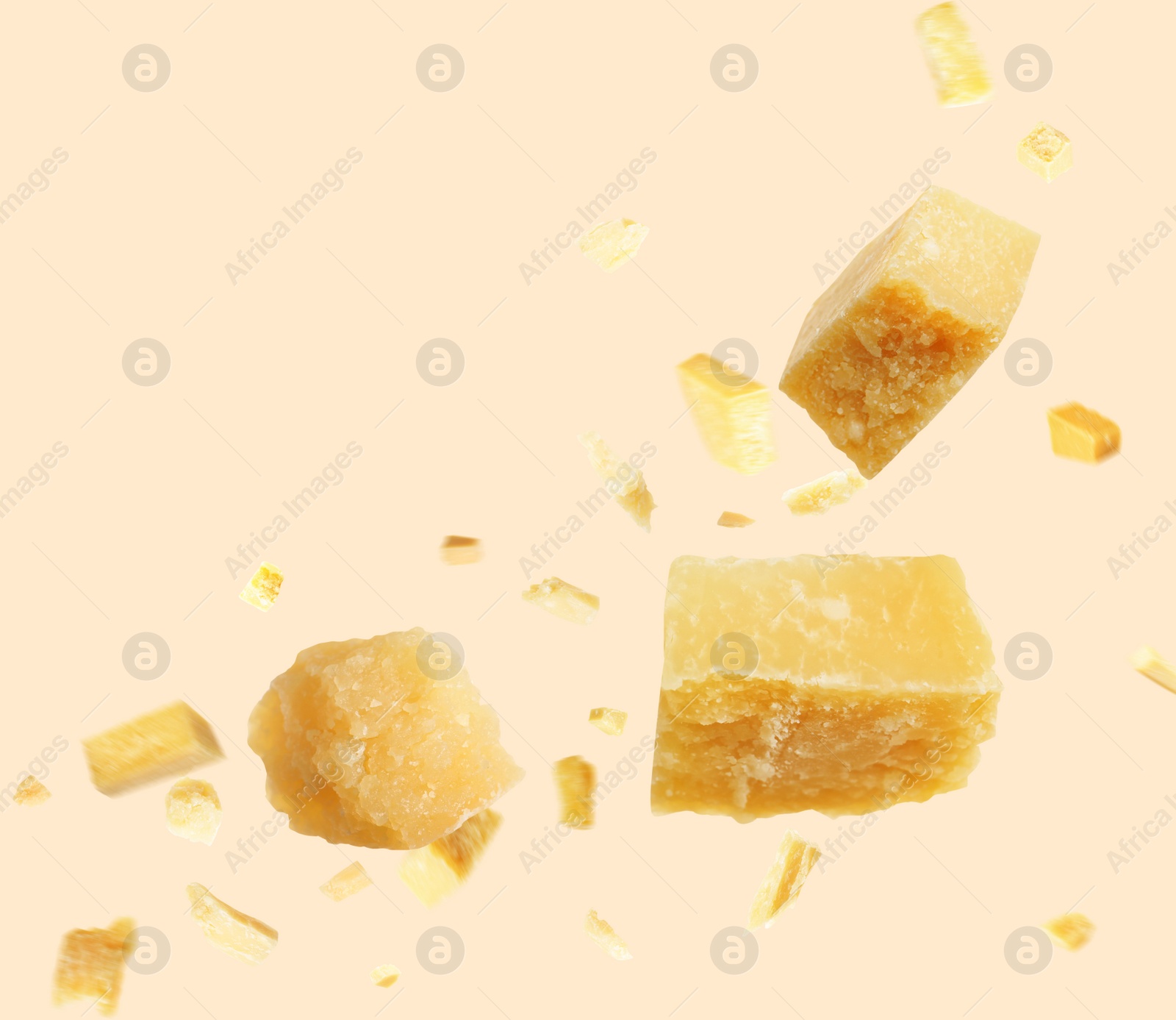 Image of Pieces of delicious parmesan cheese flying on beige background