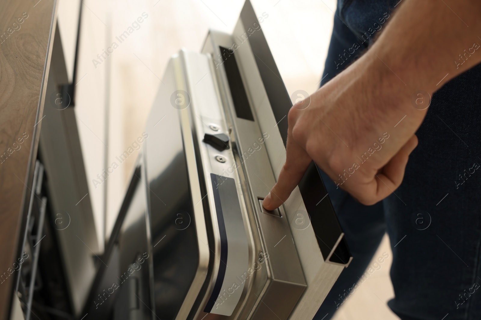 Photo of Man pushing button on dishwasher's door indoors, closeup