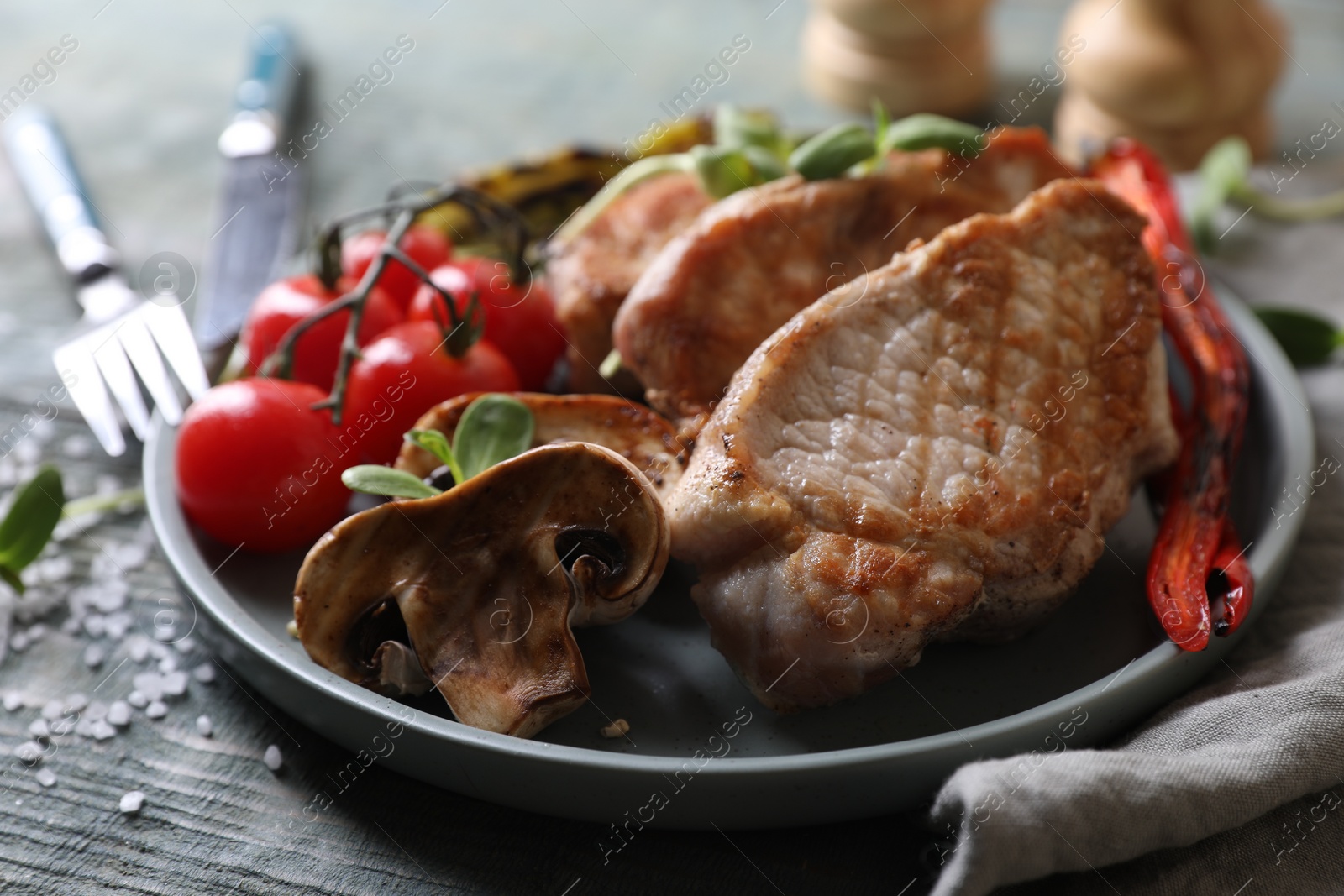 Photo of Delicious grilled meat and vegetables served on wooden table, closeup