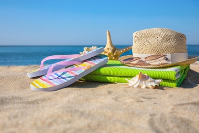 Set with stylish beach accessories on sand near sea