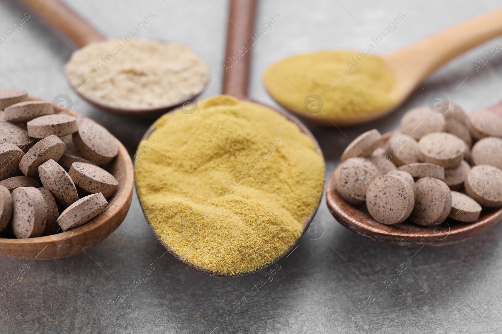 Photo of Different types of brewer's yeast on grey table, closeup