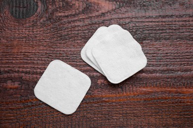 Photo of Clean cotton pads on wooden table, flat lay
