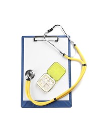 Photo of Clipboard, plastic pill box and stethoscope on white background, top view