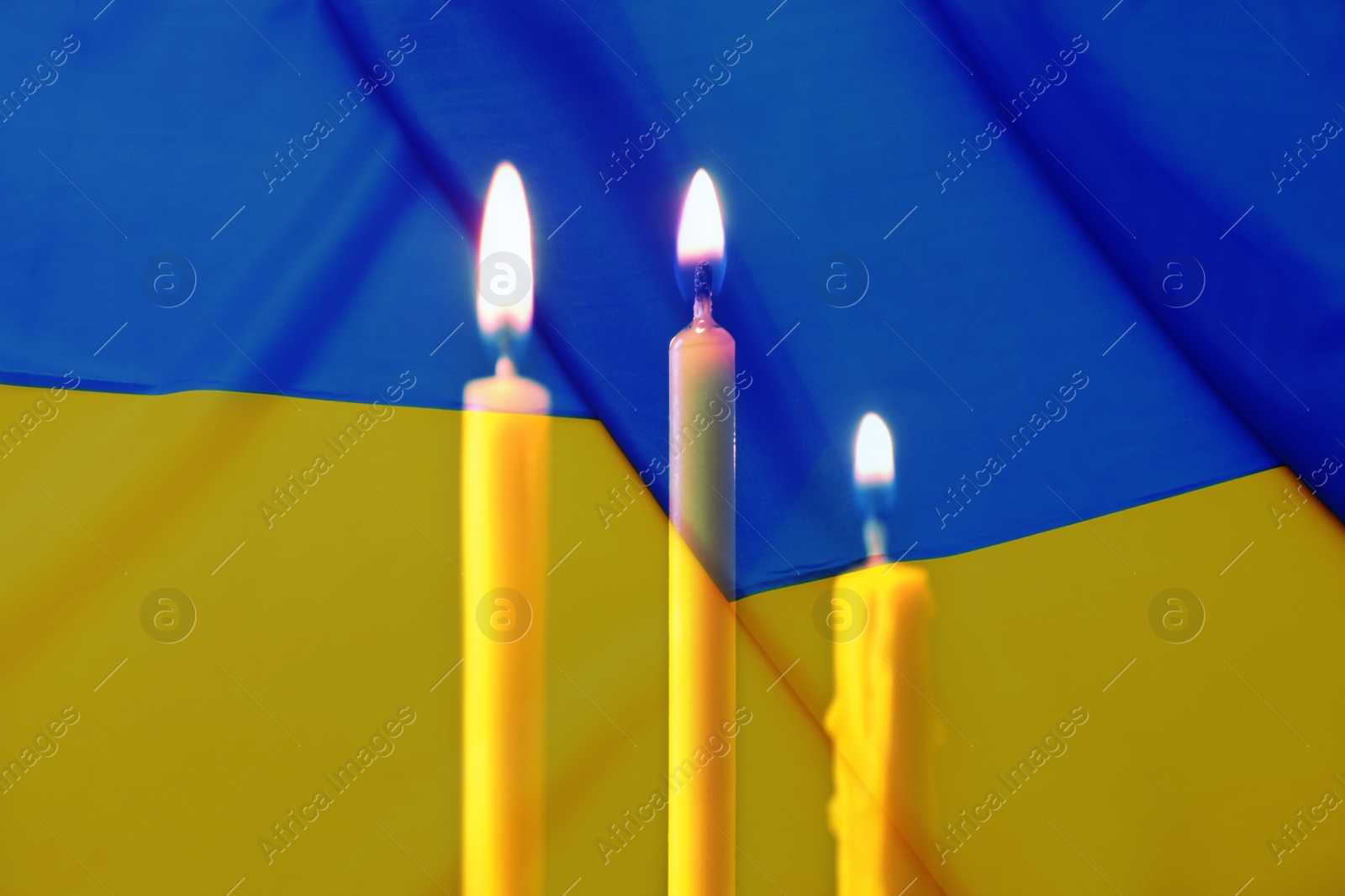 Image of Double exposure of Ukrainian national flag and burning candles