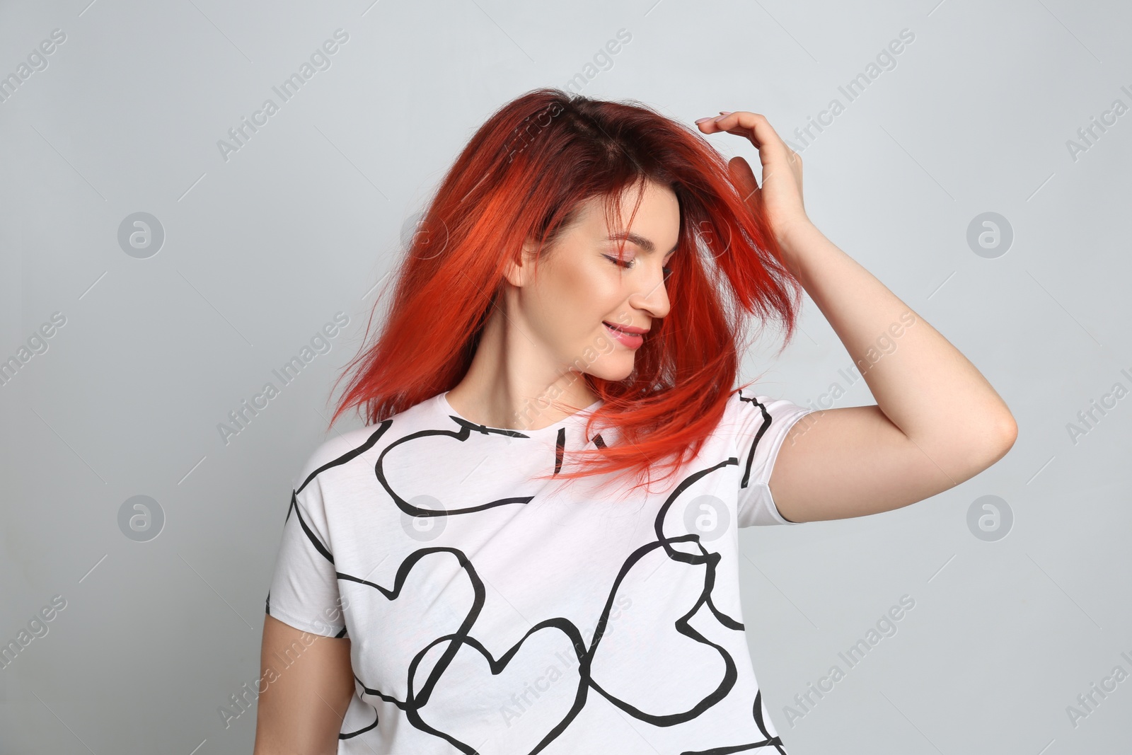 Photo of Young woman with bright dyed hair on grey background