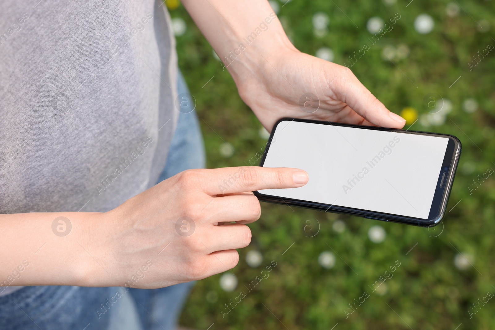 Photo of Woman using mobile phone outdoors, closeup view