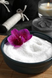 Photo of Beautiful composition with sea salt, burning candle, flowers and different spa products on grey table, closeup