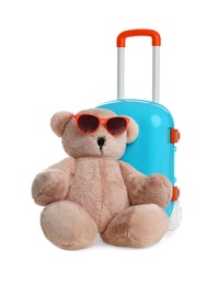 Composition with stylish little blue suitcase and teddy bear on white background