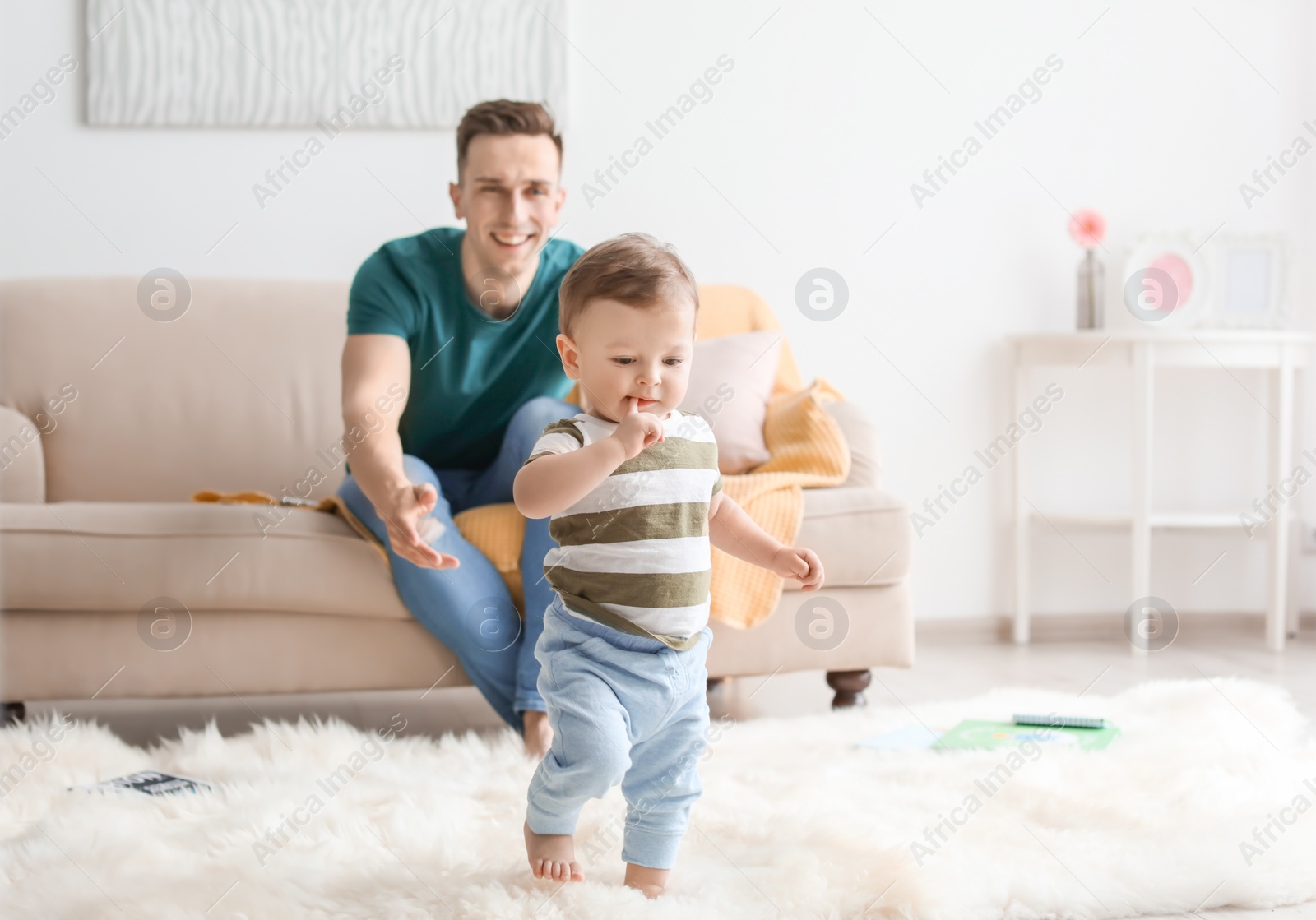 Photo of Young father with his cute little son at home