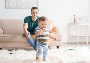 Young father with his cute little son at home