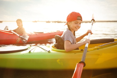 Little children kayaking on river. Summer camp activity