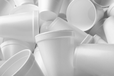 Photo of Heap of white styrofoam cups as background, closeup