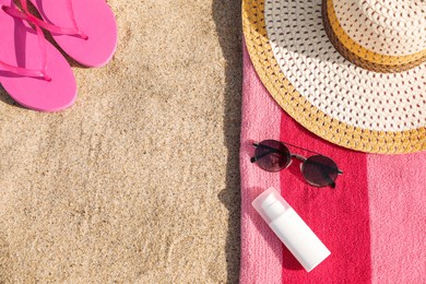 Photo of Towel and beach accessories on sand, flat lay. Space for text