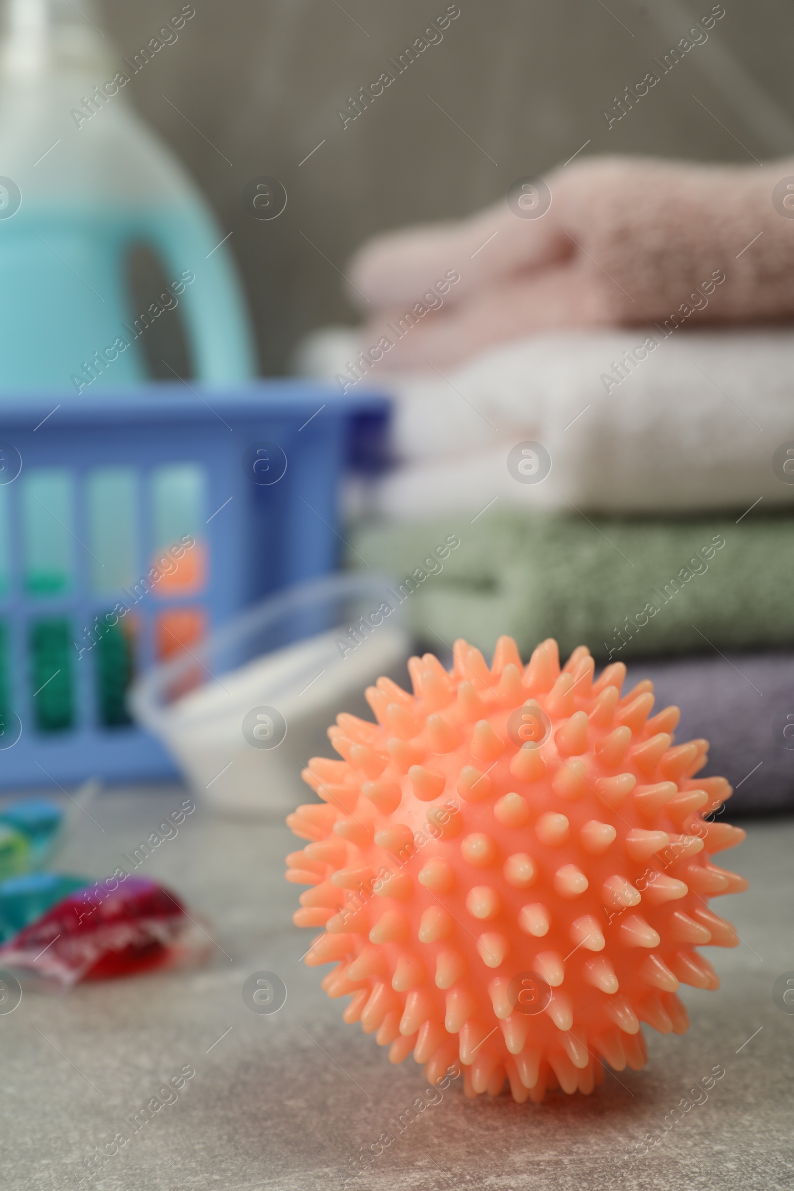 Photo of Orange dryer ball on grey marble table, closeup