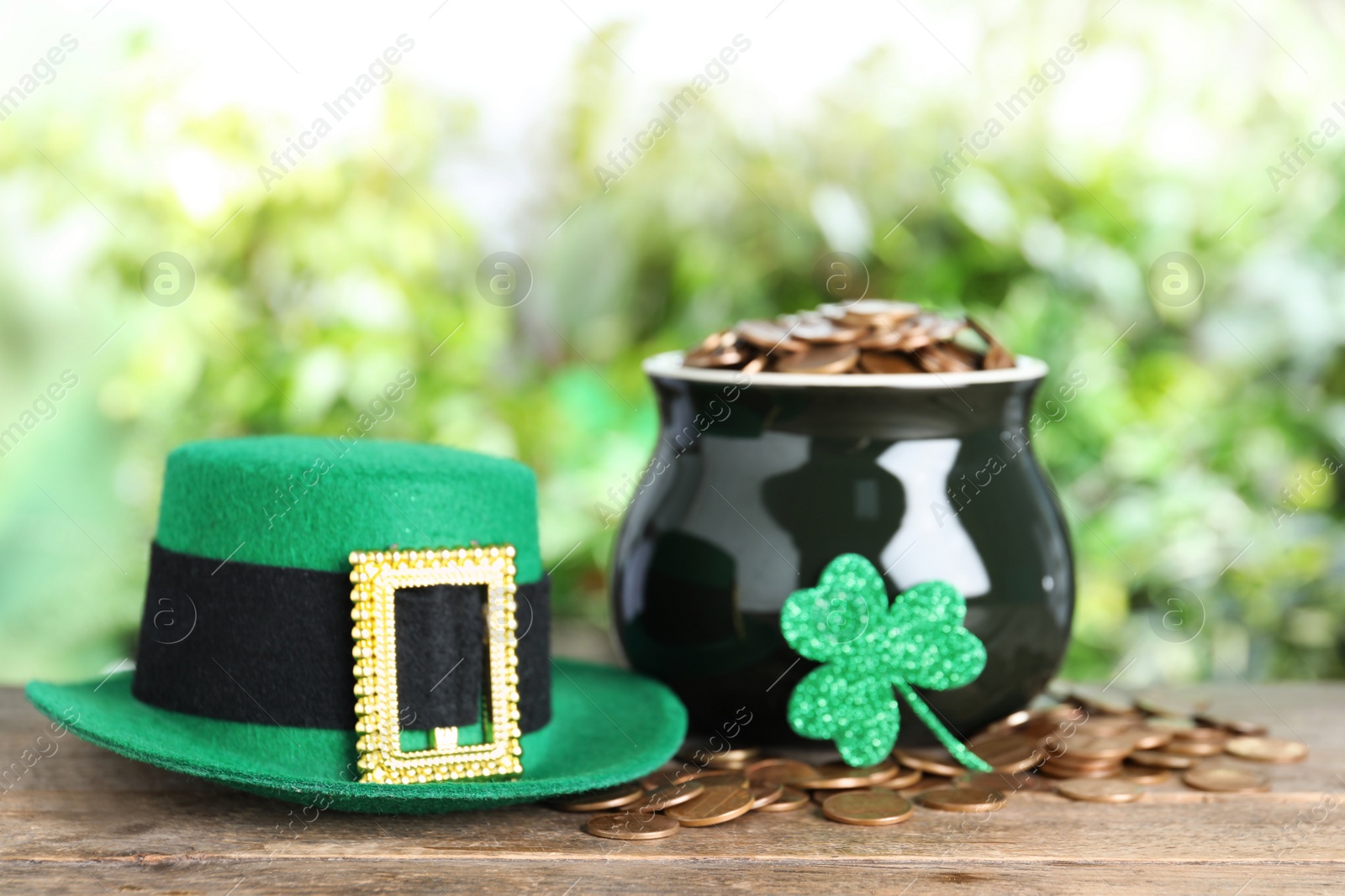 Photo of Green leprechaun hat and pot with gold coins on wooden table. St Patrick's Day celebration