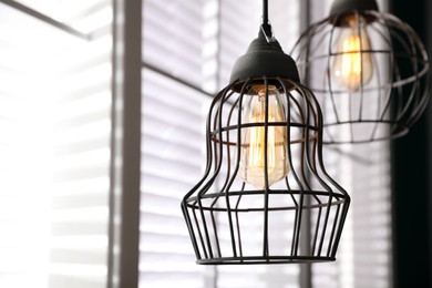 Stylish metallic pendant lamp with Edison light bulb indoors